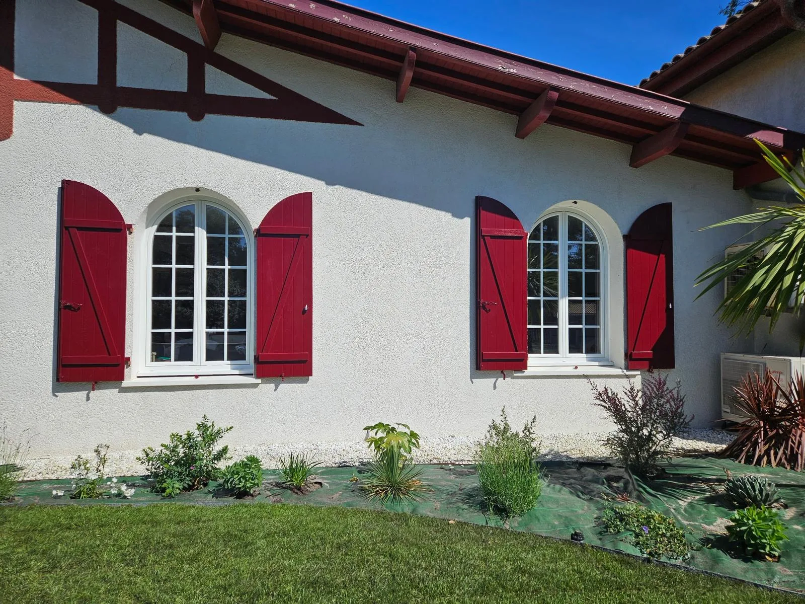 Volets battants rouges sur une façade blanche